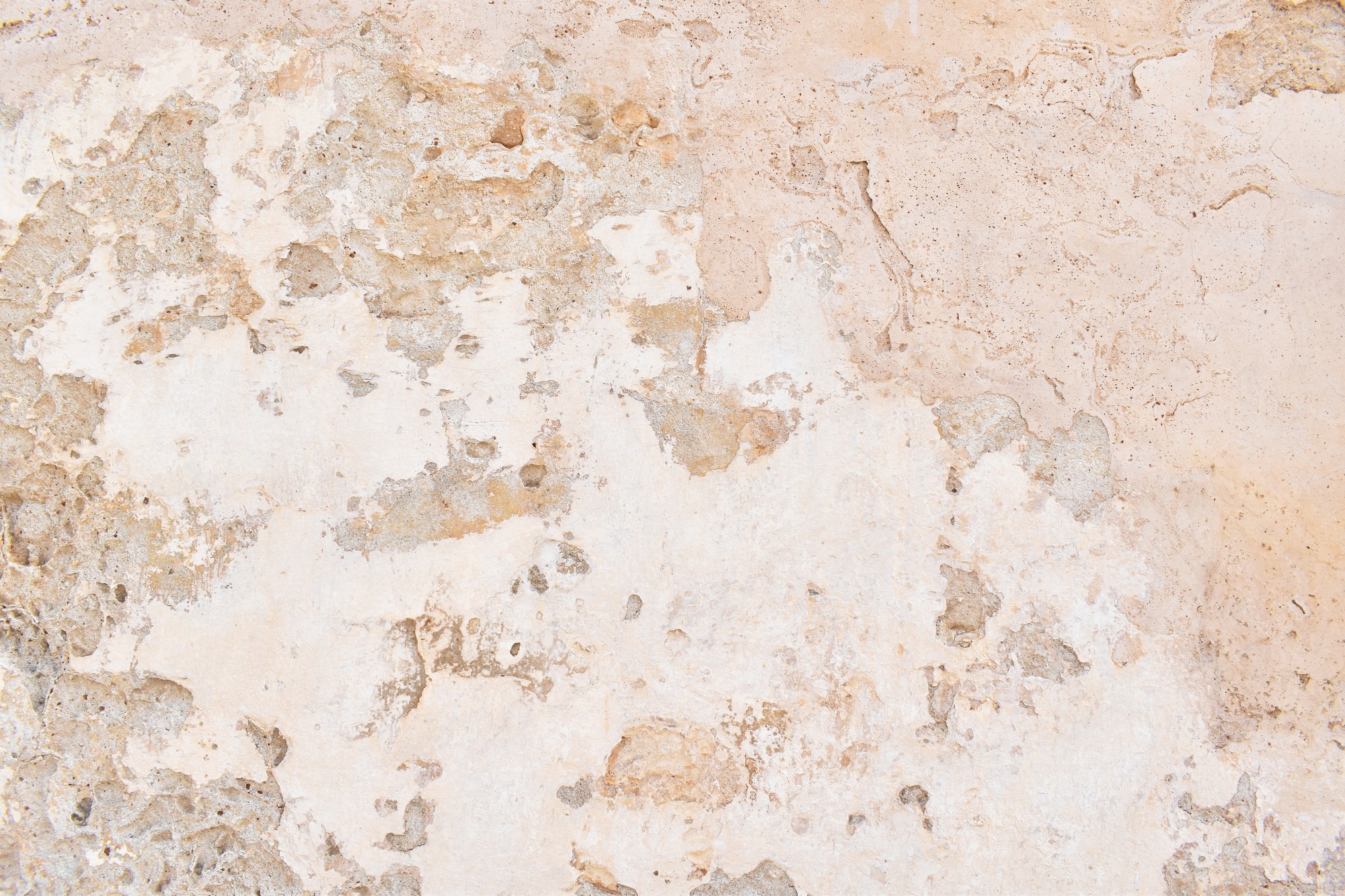 This image displays a textured surface that appears to be a section of a wall or a floor with a weathered and aged appearance. It's characterized by a multicolored pattern of wear and degradation, displaying various shades of beige and brown, with some areas where the material has chipped away to reveal different layers or different materials underneath. The texture looks rough and irregular, suggesting that the surface has seen significant exposure to elements or physical wear over time. This kind of texture is often found in old buildings, historical sites, or can be used as a design element to create a rustic or vintage look.